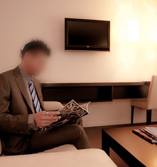 Gigolo David in a suit in hotel room